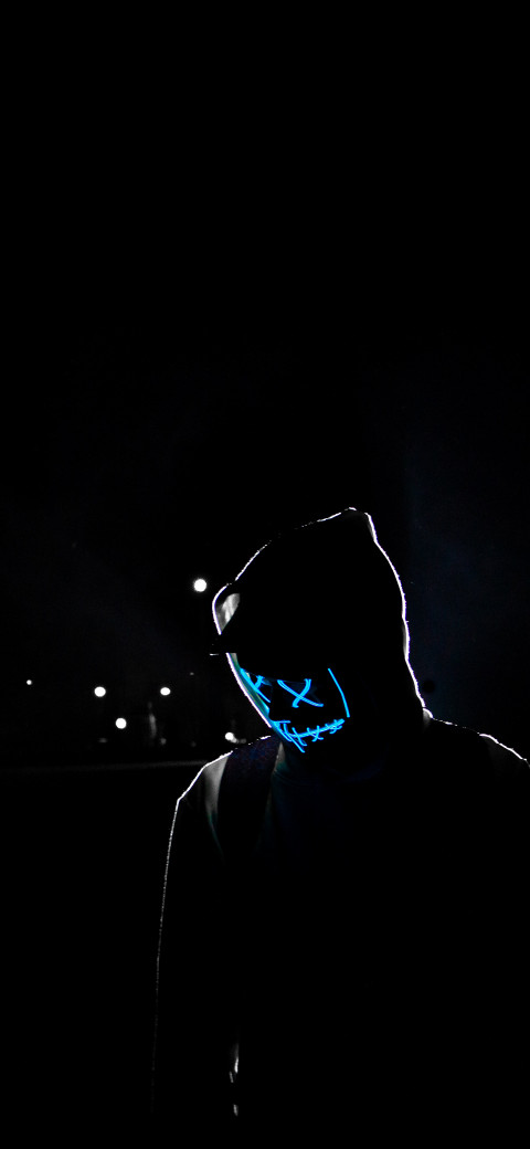 man in a hoodie with a neon mask on