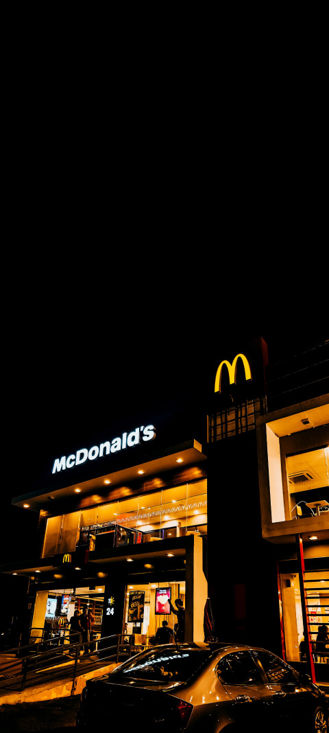mcdonald's restaurant at night with cars parked in front