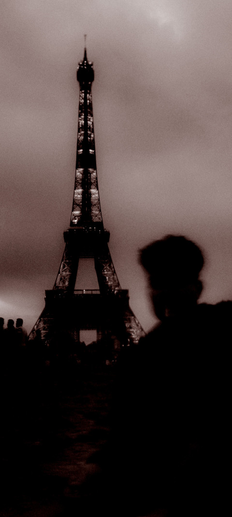 man standing in front of the eiffel tower
