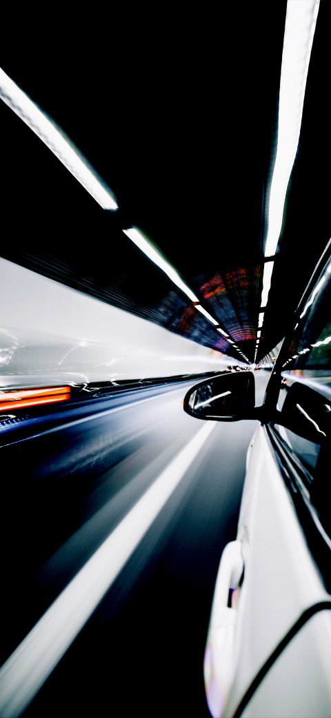 view of a car driving through a tunnel with lights