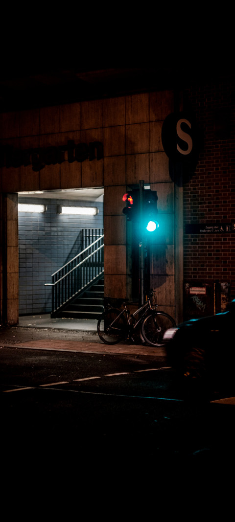 green traffic light on a street corner at night