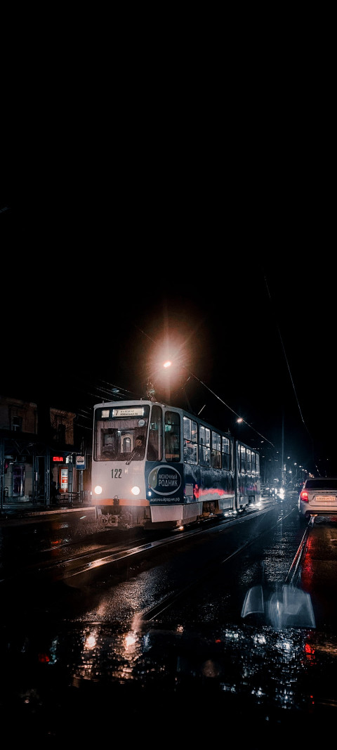 Tram driving down the street at night