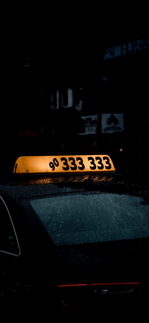 taxi sign on top of a car in the dark