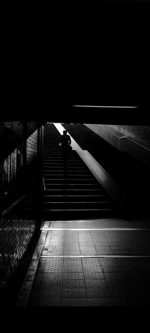 person walking down a set of stairs in the dark
