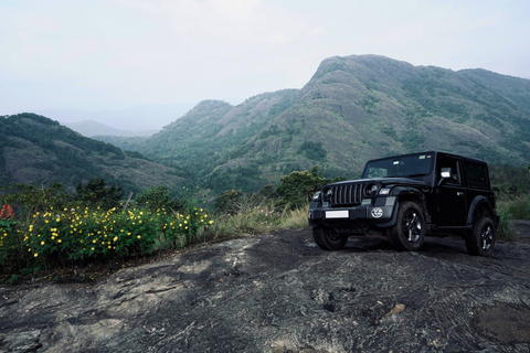 Free photo of black Mahindra Thar parked on a rocky road near a mountain