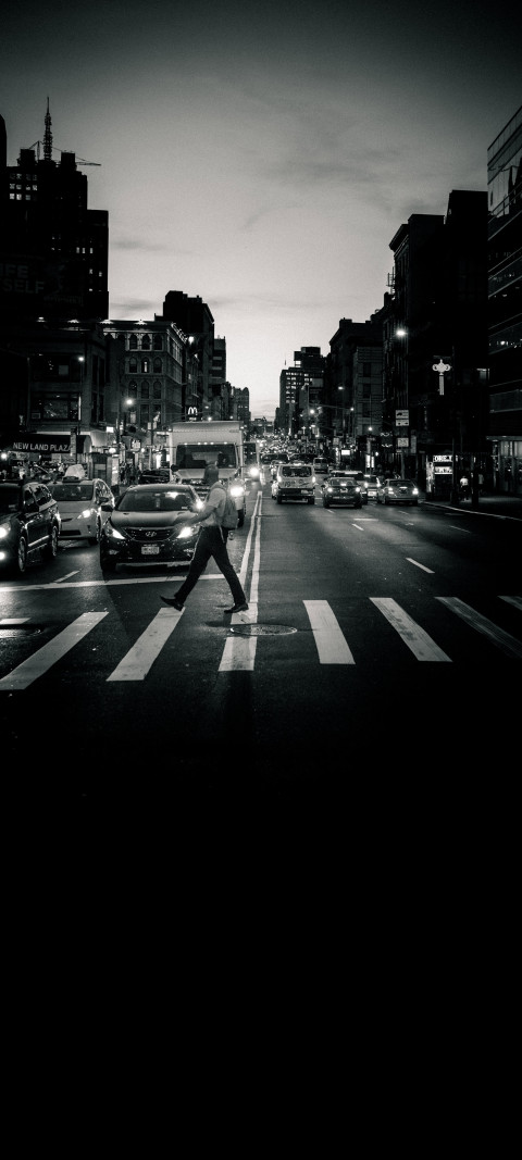man crossing a street at night