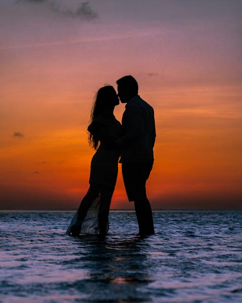 Free photo of couple kissing in the water at sunset on the beach
