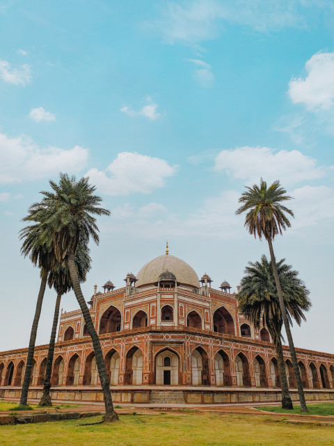 Free photo of Humayun’s Tomb surrounded by palm trees