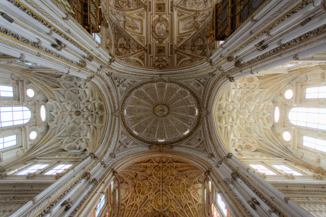 The interior of the Mezquita-Catedral de Córdoba, a grand mosque and cathedral in Córdoba, Spain. The mosque was built in the 8th century and later converted into a cathedral in the 16th century. The interior is a stunning blend of Islamic and Christian architecture, featuring intricate arches, columns, and mosaics