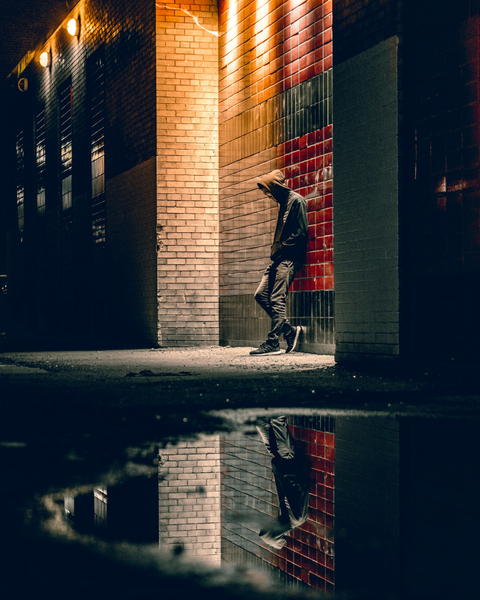Free photo of Man walking down a street at night with a hoodie on