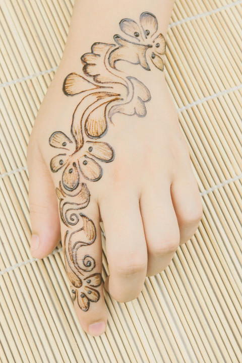 Free photo of mehndi design on back of hand with a flower