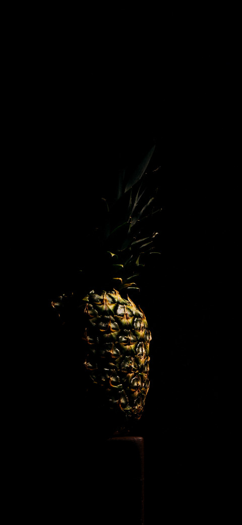 pineapple sitting on a table in the dark
