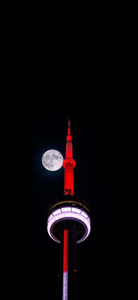 view of a tall tower with a full moon in the background