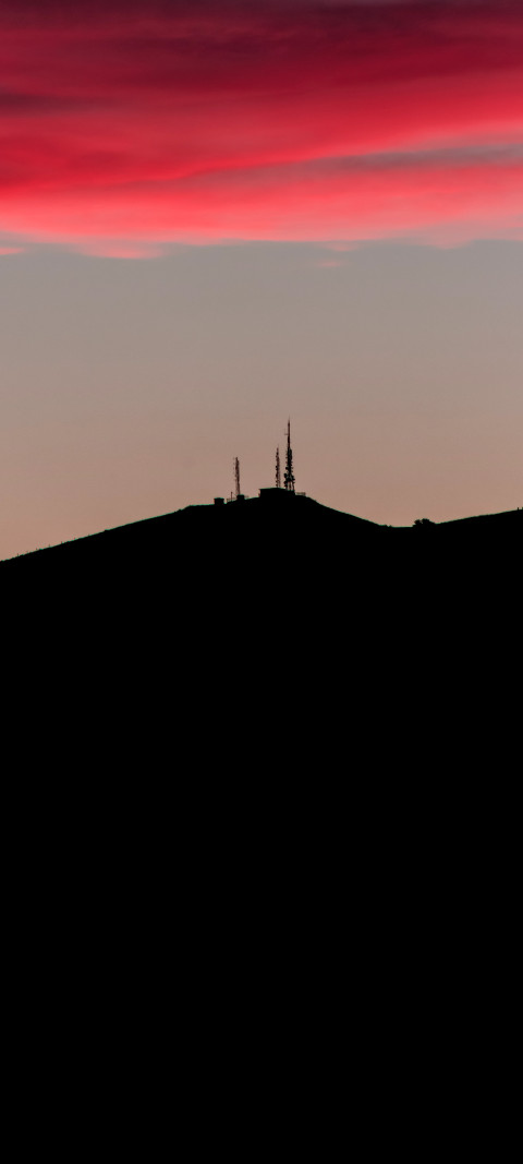 view of a hill with a few radio towers on top