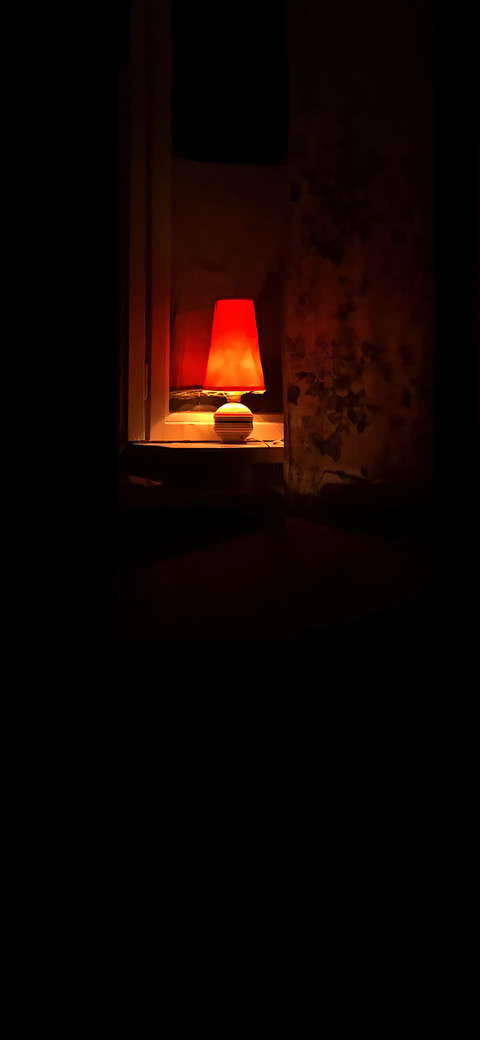 red lamp light that is on table in the dark
