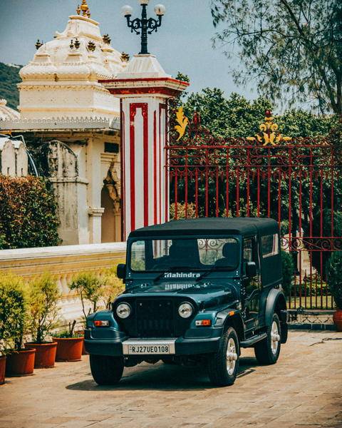 Free photo of old mahindra thar parked in front of a building