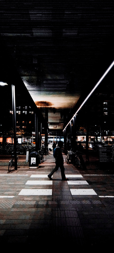 man walking down the street at night