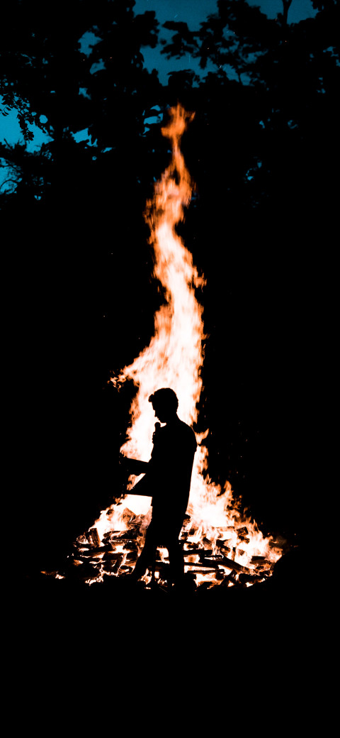 man standing in front of a fire