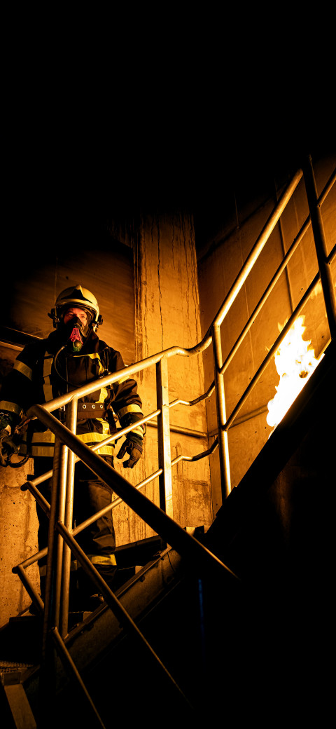 firefighter standing on a staircase in a building at night