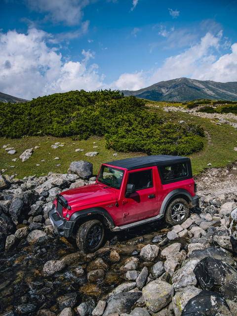 Free photo of red Mahindra Thar driving on a rocky trail