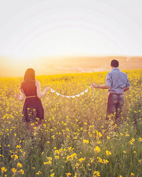 Free photo of two people standing in a field holding a string