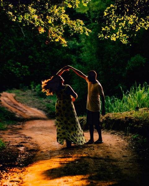 Free photo of two people that are dancing on a dirt road