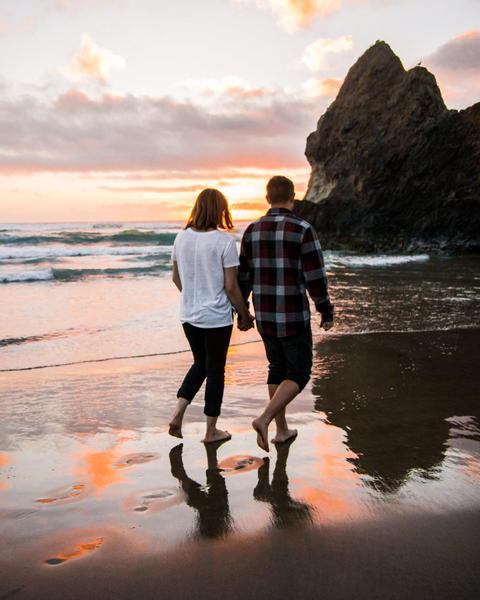 Free photo of two people walking on the beach holding hands