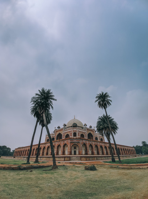 Free photo of Wide angle view of a Humayun’s Tomb with palm trees in front of it