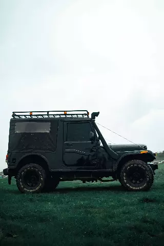 black mahindra thar parked in a field
