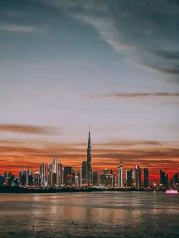 Burj Khalifa and Downtown Dubai skyline at sunset with a red sky