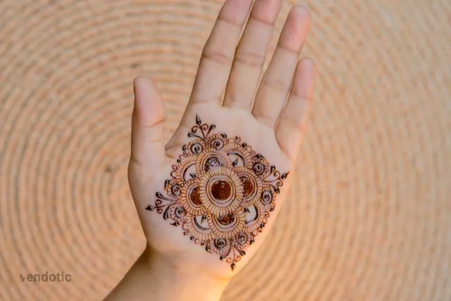 close up of a person's hand with a henna tattoo
