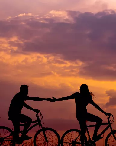 couple are riding bikes in the sunset