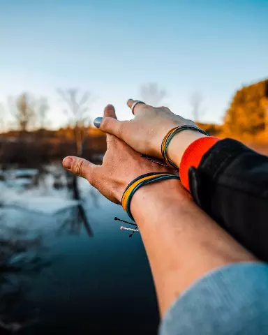 couple holding their hands out to the water with their fingers