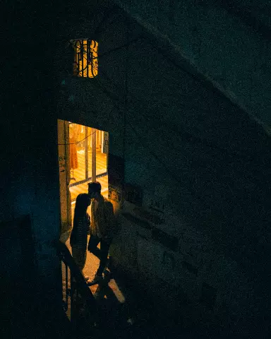 couple standing outside of a building at night