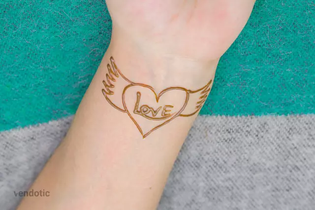 Henna on arm with heart and wings