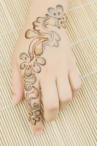 mehndi design on back of hand with a flower