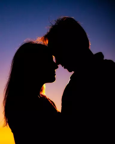 silhouette of a couple kissing in front of a sunset