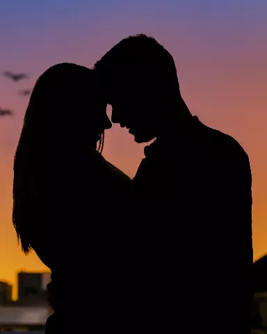silhouette of a couple kissing in front of sky