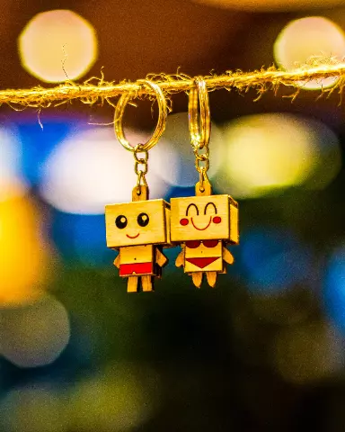 two wooden toy characters hanging from a rope