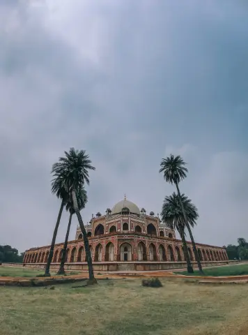 Wide angle view of a Humayun’s Tomb with palm trees in front of it